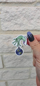 Christmas Ball Sticker. Alien Hand Holding Earth. Christmas Ornaments. Christmas Decorations. Trippy Xmas Sticker.